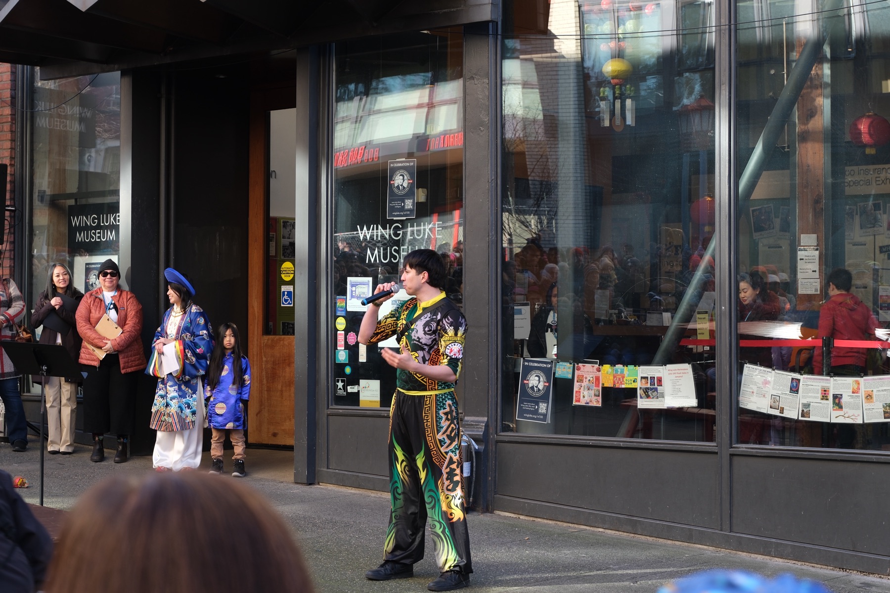 A young Mak Fai performer speaking to a crowd outside the Wing Luke Museum